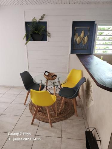 een kamer met stoelen, een tafel en een aanrecht bij Patoulocation in La Trinité