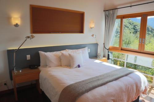 Arthur's Bay的住宿－千洞灣度假酒店，一间卧室设有一张大床和一个窗户。