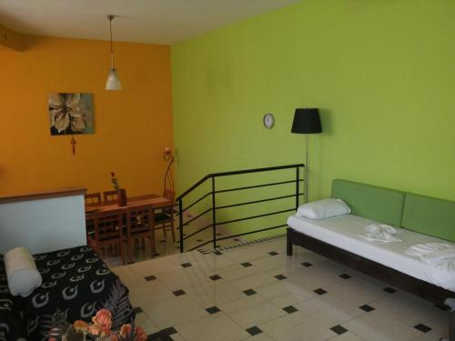 a room with two beds and a dining room with a table at Mythos- Platanias- Hotel -Apts in Plataniás