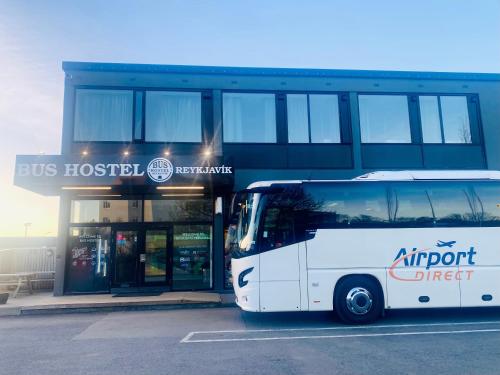 um autocarro branco estacionado em frente a um edifício em Bus Hostel Reykjavik - Reykjavik Terminal em Reykjavík