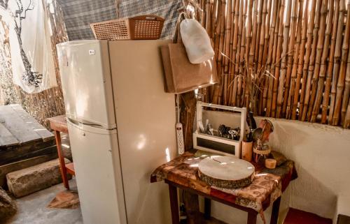 cocina con nevera y mesa con microondas en Bambuddha - Garden Suite at Lakehouse, en San Pedro La Laguna
