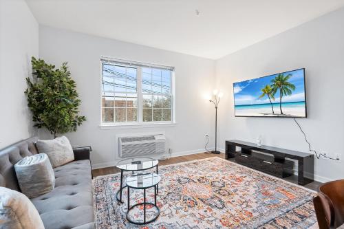 a living room with a couch and a table at Modern 2BR 2BA Condo Sleeps 8 with Gym Laundry 20 Min to NYC in Jersey City
