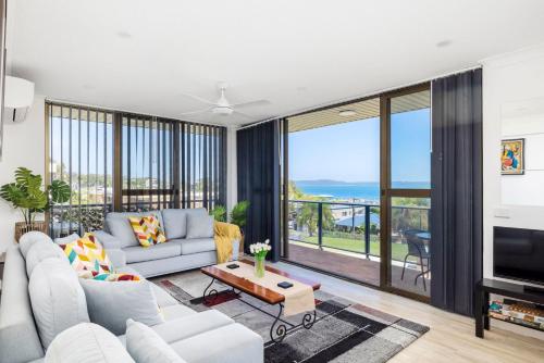 a living room with a couch and a tv at Views and Pool in a Great Location in Nelson Bay in Nelson Bay