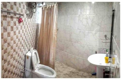 a bathroom with a toilet and a sink at Modern 2 bedroom apartment Near Nainital and Kaichi Dham SF4 in Nainital