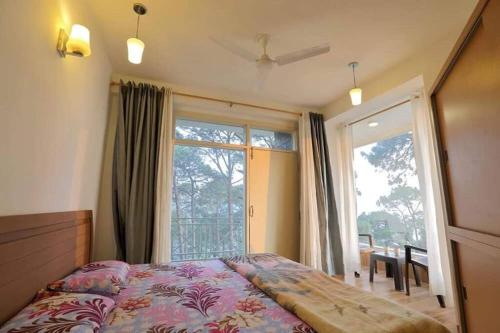 a bedroom with a bed and a large window at Modern 2 bedroom apartment Near Nainital and Kaichi Dham SF4 in Nainital