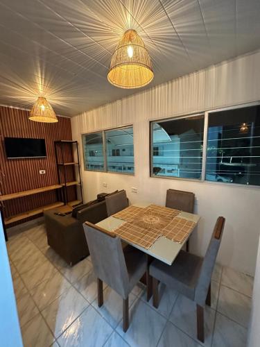 un soggiorno con un tavolo e un divano di Casa da Praia Japaratinga a Japaratinga