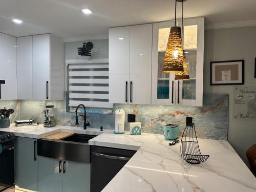 a kitchen with white cabinets and a sink at Casa Blue Pelican. in Marathon
