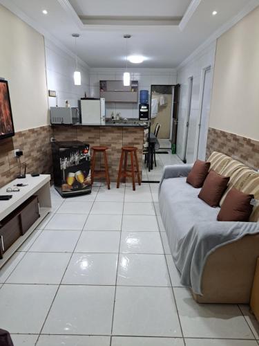 a living room with a couch and a kitchen at Linda Casa Itamaracá in Jaguaribe