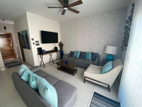 uma sala de estar com um sofá e uma televisão em Casa Completa con Alberca privada em La Paz