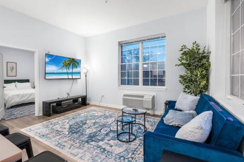 a living room with a blue couch and a table at Urban Luxury Condo: 20 Mins to NYC (Gym, Laundry) in Jersey City