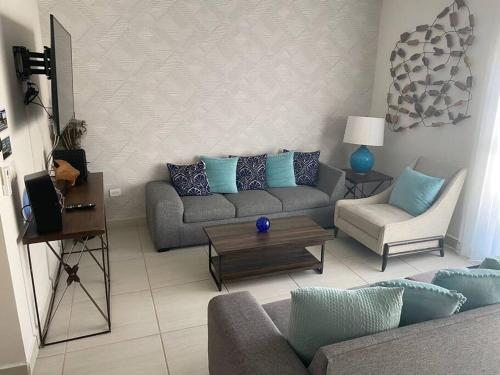 uma sala de estar com um sofá e uma mesa em Casa Completa con Alberca privada em La Paz