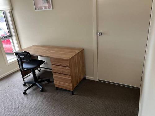 a wooden desk with a chair next to a door at Tasha's Apartments - Andrews Farm in Smithfield