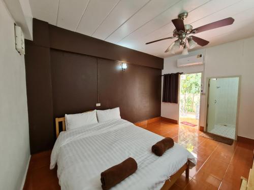 a bedroom with a large bed with a ceiling fan at ศิริภูมิอพาร์ทเม้น ซอย.9 in Ban Lat Krachaeng