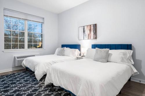 Duas camas brancas num quarto com uma janela em Discover Urban Luxury: Condo Only 20 Min to NYC em Jersey City