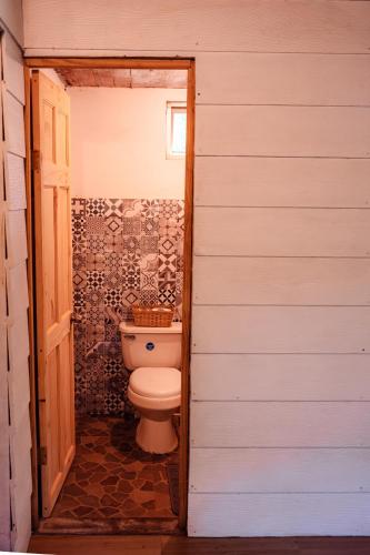a bathroom with a toilet in a room at Miles Away in Cóbano