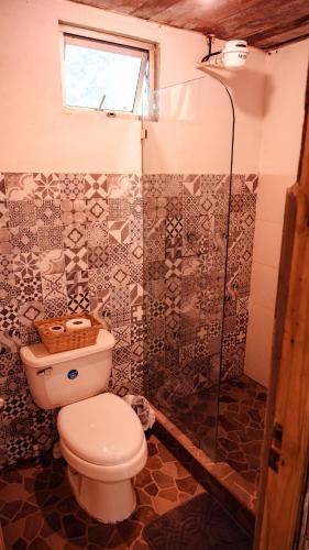 a bathroom with a toilet and a shower at Miles Away in Cóbano