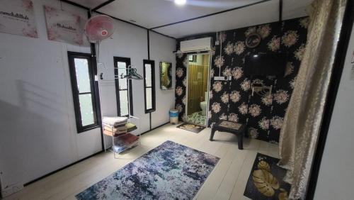 a room with floral wallpaper and a hallway with a rug at THE K KABIN in Pekan