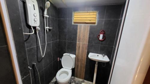 a bathroom with a shower and a toilet and a sink at THE K KABIN in Pekan