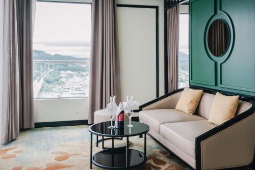 a living room with a couch and a table at La Vela Hue Hotel in Hue