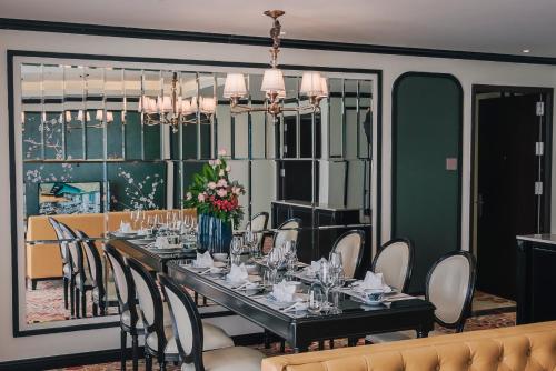 a dining room with a long table and chairs at La Vela Hue Hotel in Hue