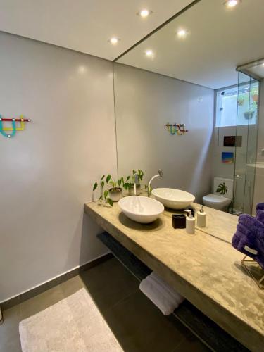 a bathroom with two sinks and a mirror at Casa Irauna in Sao Paulo