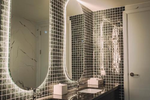 a bathroom with a mirror and a sink at La Vela Hue Hotel in Hue