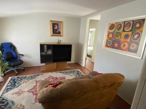 uma sala de estar com um sofá e uma televisão em Two bedroom, living/dining room em Bellport