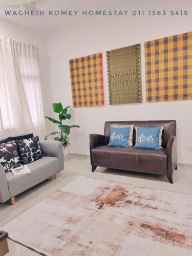 a living room with two couches and a rug at WAGHEIH KOMEY HOMESTAY in Putrajaya