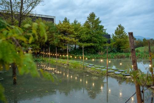 - un jardin avec des lumières dans l'eau la nuit dans l'établissement Good Stand, à Suao