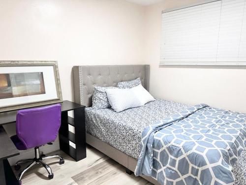 a bedroom with a bed and a desk with a purple chair at Main floor Room with Queen Bed, Free Parking and Free wi-fi and shared washroom near Fairview Park Mall (Room 2) in Kitchener