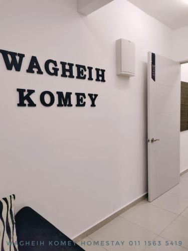 a wall with a sign for azauth koney on a wall at WAGHEIH KOMEY HOMESTAY in Putrajaya