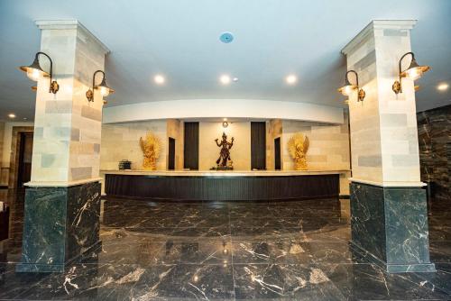 a lobby with a statue in the center of a building at Taman Prakerti Bhuana Hotel in Gianyar