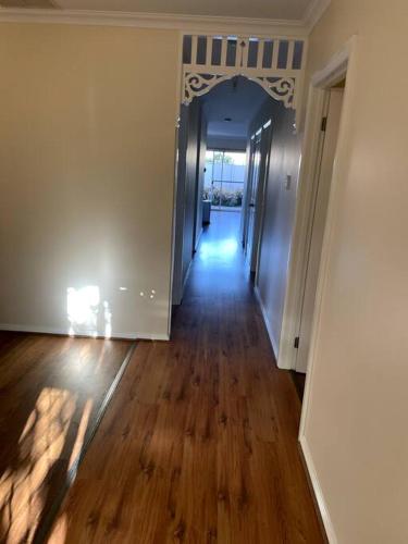 an empty room with a hallway with wooden floors and a hallwayngthngthngthngth at Tasha's Apartments in Angle Park - N38 in Woodville
