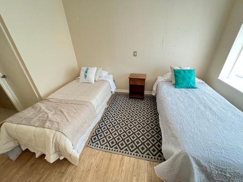 two beds in a small room with a window at Departamento Cercano al Lago Llanquihue in Puerto Varas