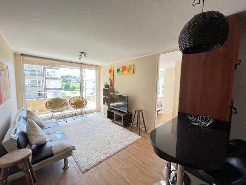 a living room with a couch and a table at Departamento Cercano al Lago Llanquihue in Puerto Varas