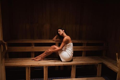 a woman in a white dress sitting on a bench at The Ritz-Carlton, Laguna Niguel in Dana Point