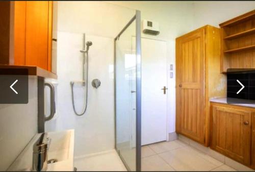 a bathroom with a shower with a glass door at Peace and Aroha Mangawhai - Apartment in Mangawhai