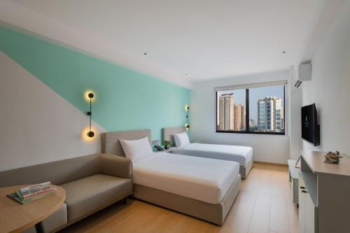 um quarto de hotel com uma cama e um sofá em LNCommunity Guangzhou Haizhu Branch em Guangzhou