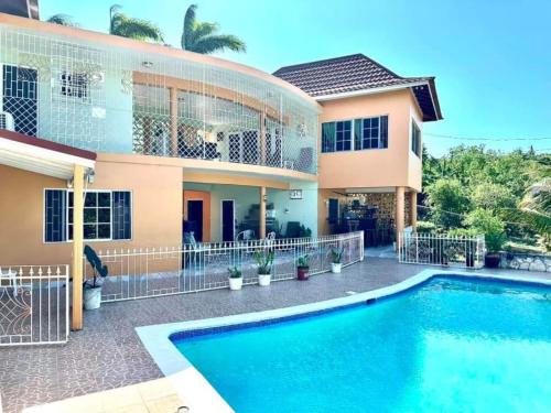 a house with a swimming pool in front of it at Chaudhry House Montego Bays- 2nd floor apt in Montego Bay