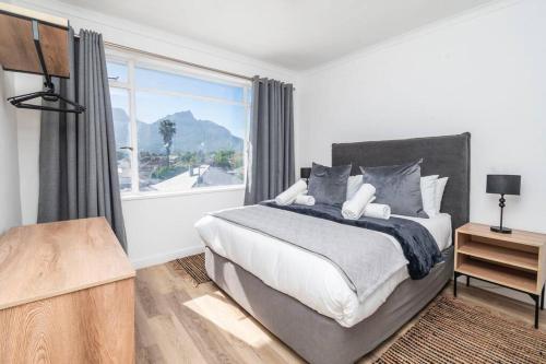 sypialnia z łóżkiem i dużym oknem w obiekcie Apartment with stunning views of Table Mountain w Kapsztadzie