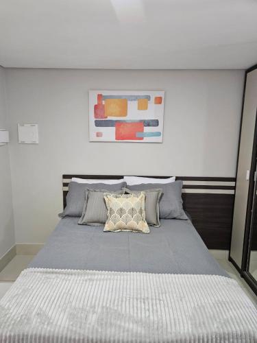 - une chambre avec un grand lit et un mur blanc dans l'établissement Alto Da Serra Villas, à Bananeiras