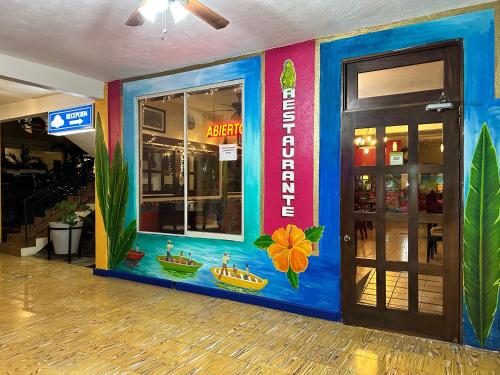 a store front with a colorful wall in a building at Hotel Cosmos in Tamasopo