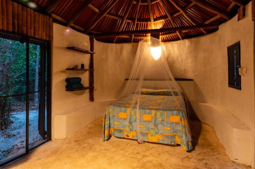 ein Schlafzimmer mit einem Bett mit Moskitonetz in der Unterkunft Villa Maya - Glamping - Natural Reserve in Cozumel