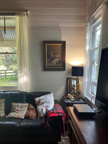 a living room with a black couch and a window at The Bay Rose in Forrest