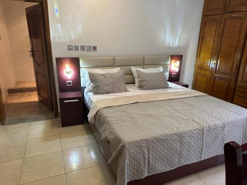 D Barfi Guesthouse, excellent location في كوماسي: غرفة نوم بسرير كبير فيها مصباحين