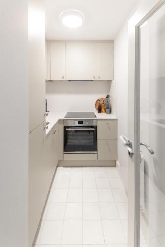 a kitchen with white cabinets and a stove at Urban Rest Merrion Square Apartments in Dublin