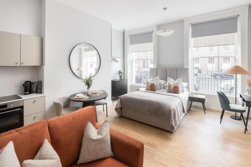 ダブリンにあるUrban Rest Merrion Square Apartmentsのベッドルーム1室(ベッド1台付)、リビングルームが備わります。