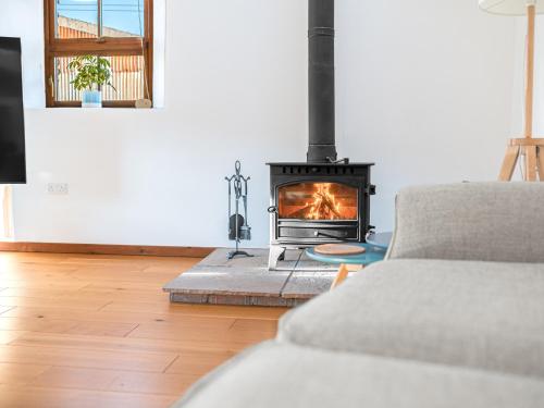 a living room with a fireplace and a couch at Swallow Barn in Cockermouth
