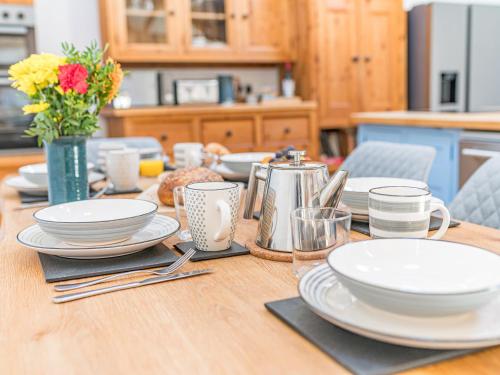 a wooden table with plates and utensils on it at Swallow Barn in Cockermouth