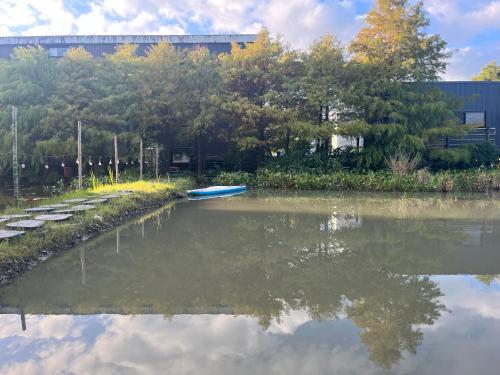 une rivière avec un bateau bleu au milieu dans l'établissement Good Stand, à Suao